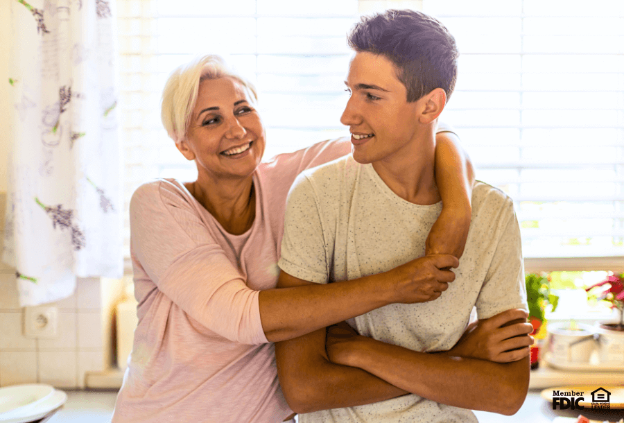 A mother hugs her son who is saving for college.