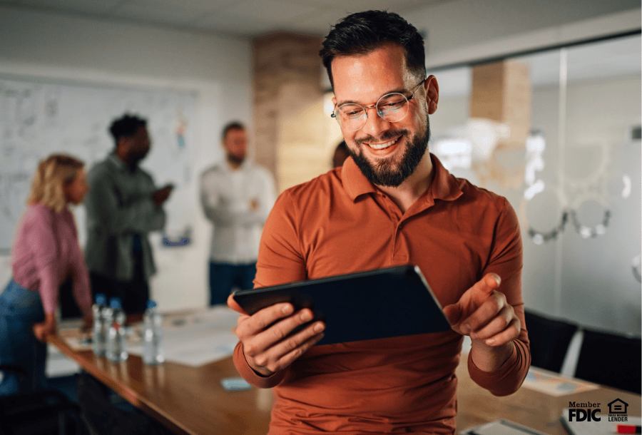 Business leader using a tablet to view his business money market account.