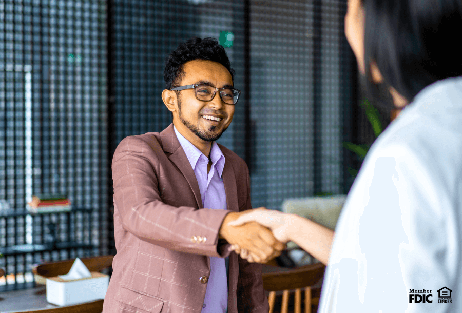 A business owner shakes hands with a banker after signing up for Treasury Management services.
