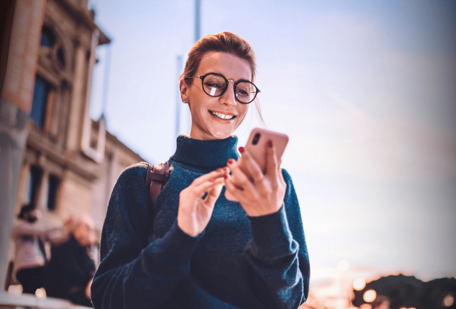 Woman using a mobile budgeting app to track spending, set goals, and more.