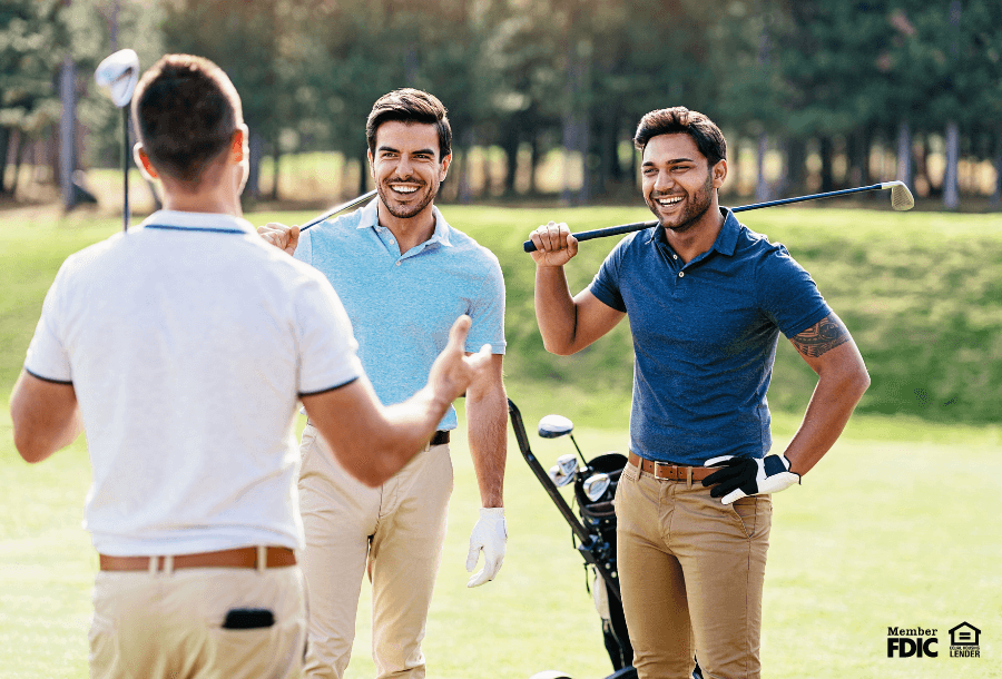 three men play golf on a sunny day while talking business loans.