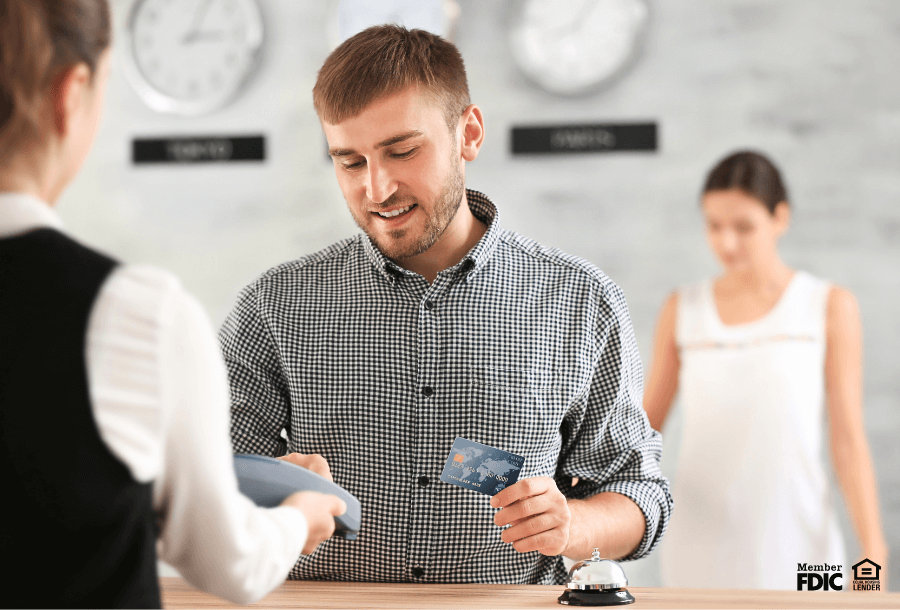 A young man paying for services with a debit card.