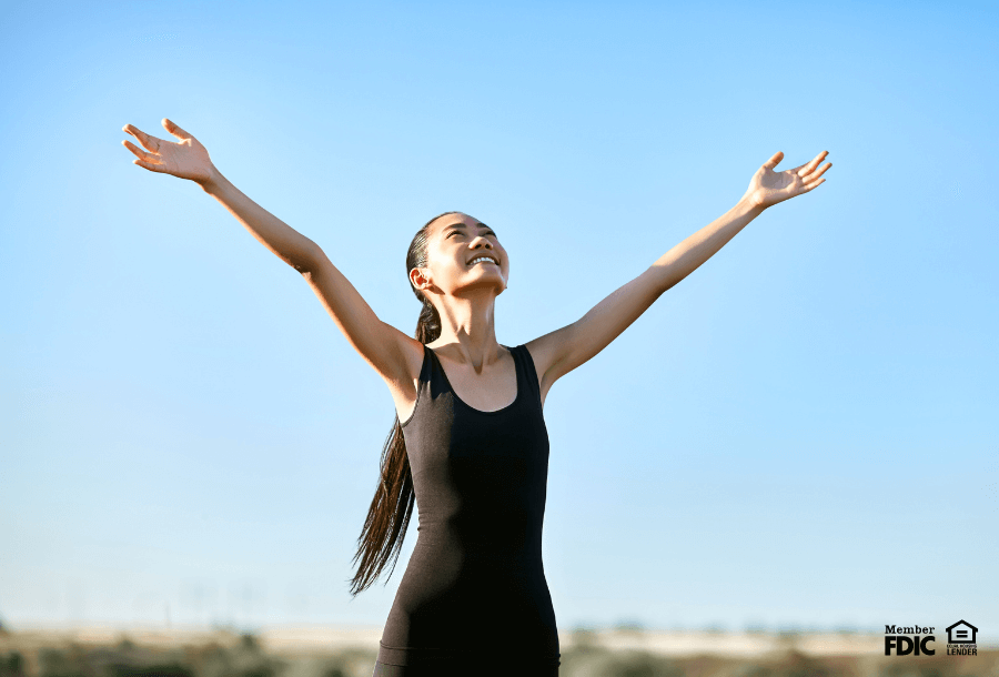 a woman celebrates because she's paid off her student loans. 