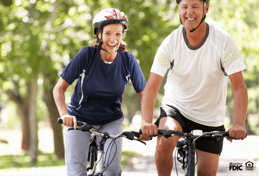 A man and woman enjoy a bike ride in the woods. 
