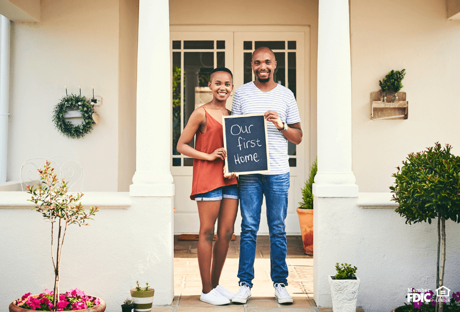 First time home owners pose with their new house