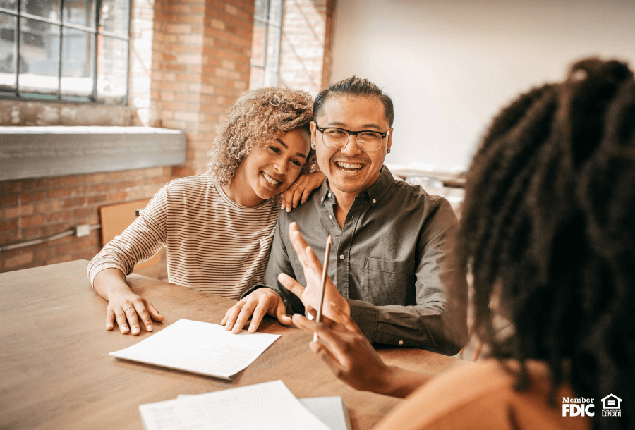 A couple fills out the paperwork to get a mortgage from a bank.