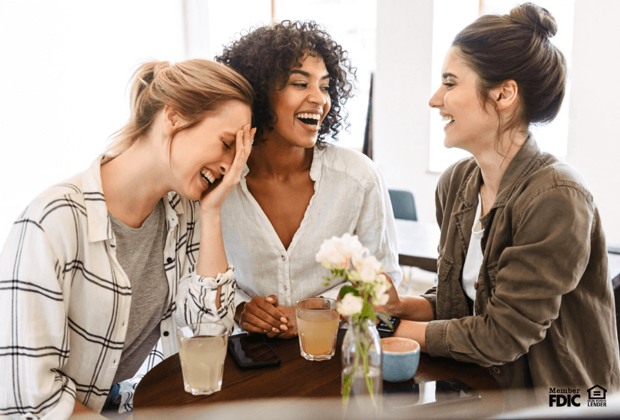 Three friends discuss their financial habits together over coffee