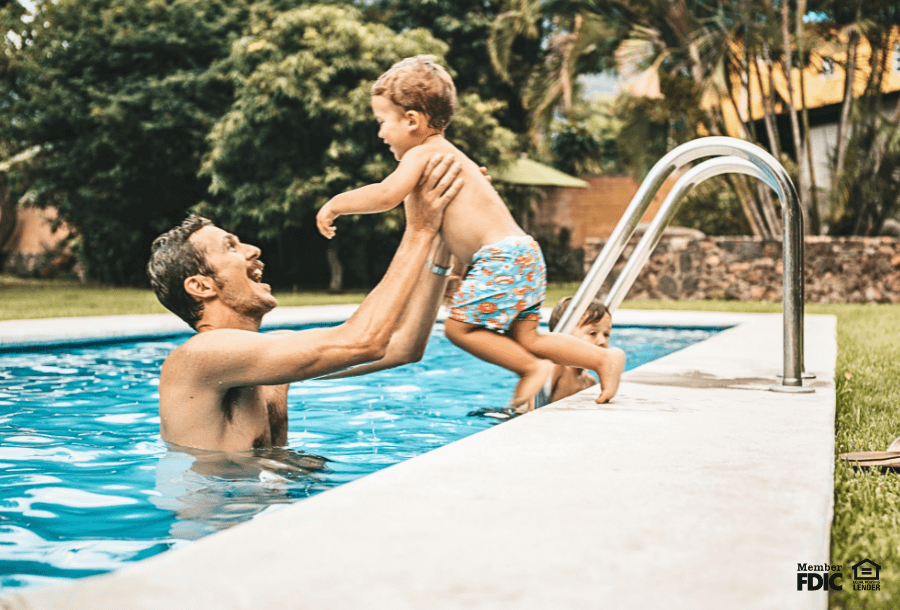 A father and son swim together in their backyard pool financed by a HELOC.