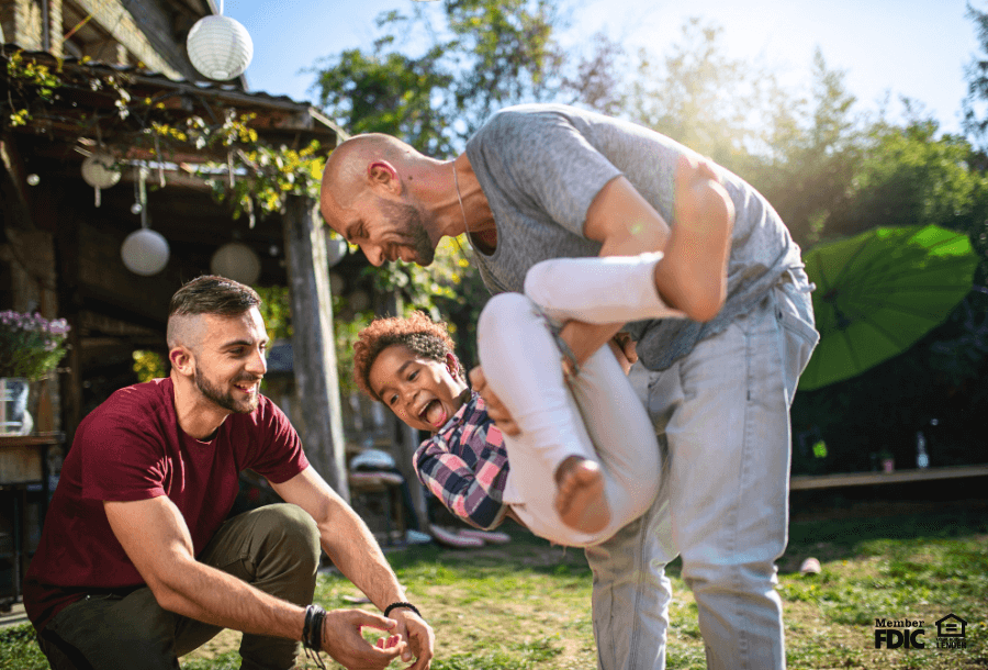 Dads play with their child in the backyard they redid with a HELOC.