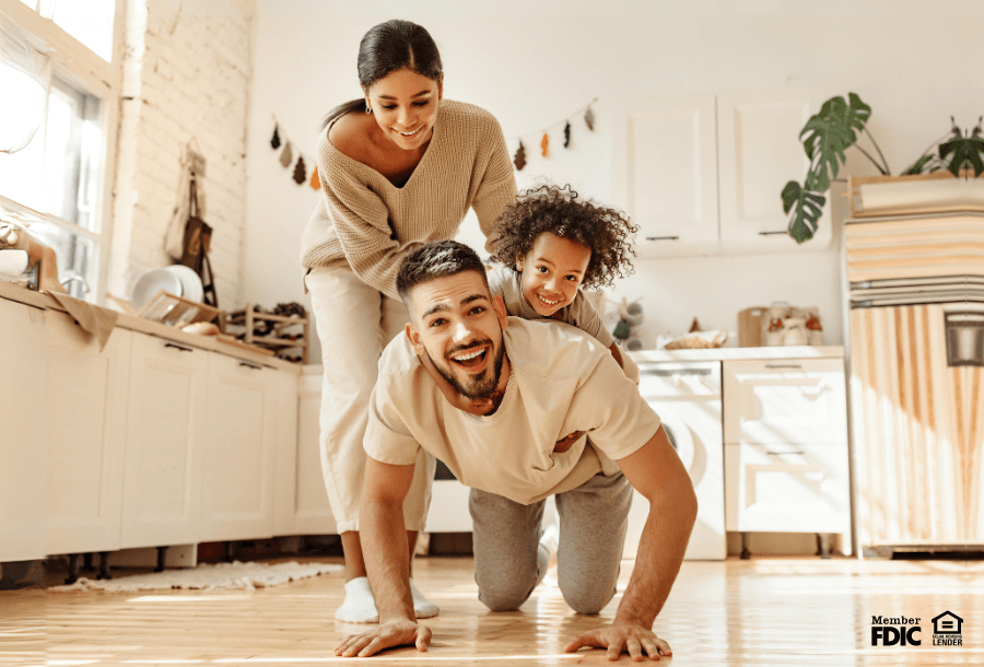 a family plays in the kitchen celebrating their new personal loan.